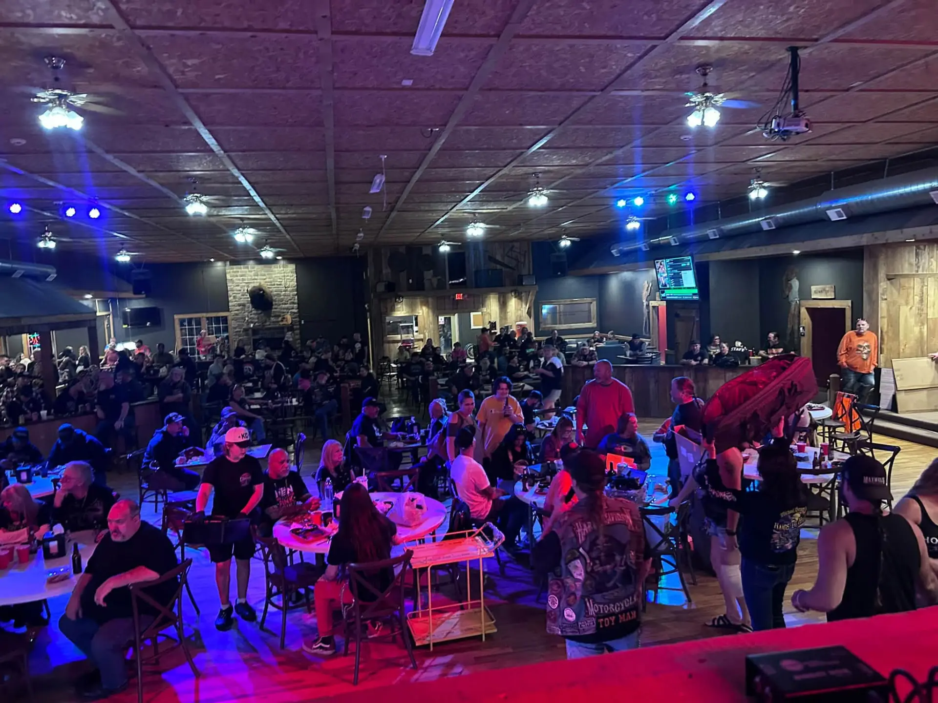 The crowd inside Chrome viewed from the stage area, with ceiling fans and colored lights overhead
