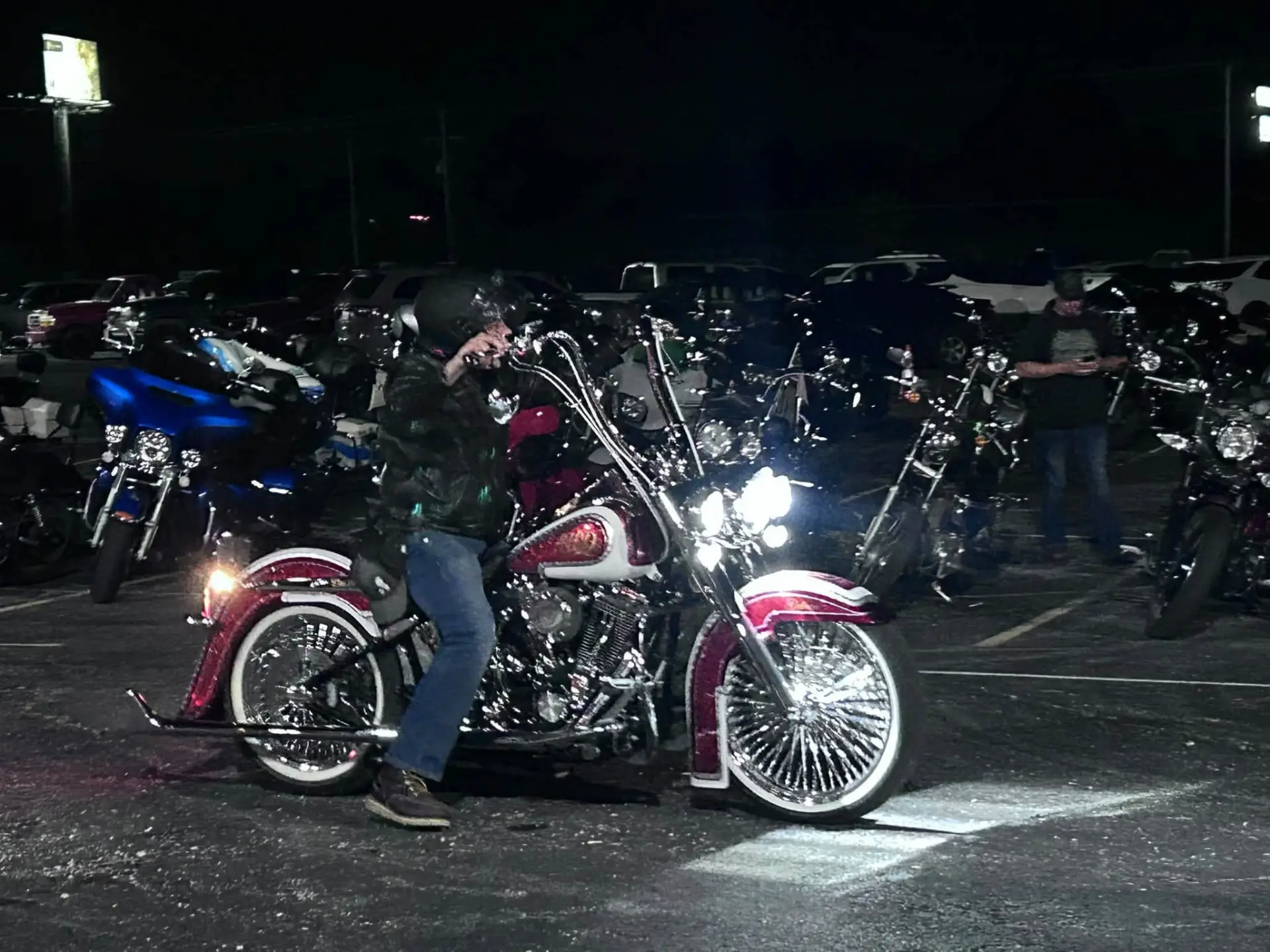Motorcycles parked outside Chrome at night, a red and white bike in front