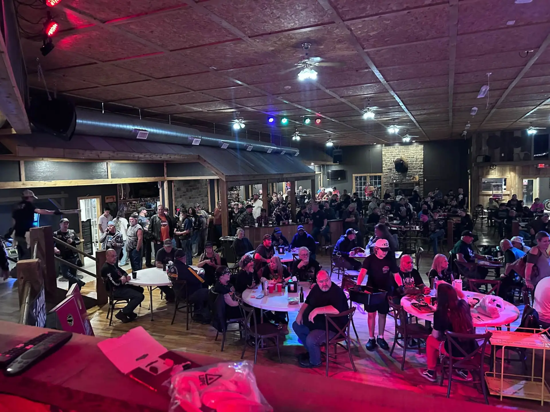 A full room of guests seated at round tables inside Chrome under red and blue stage lights